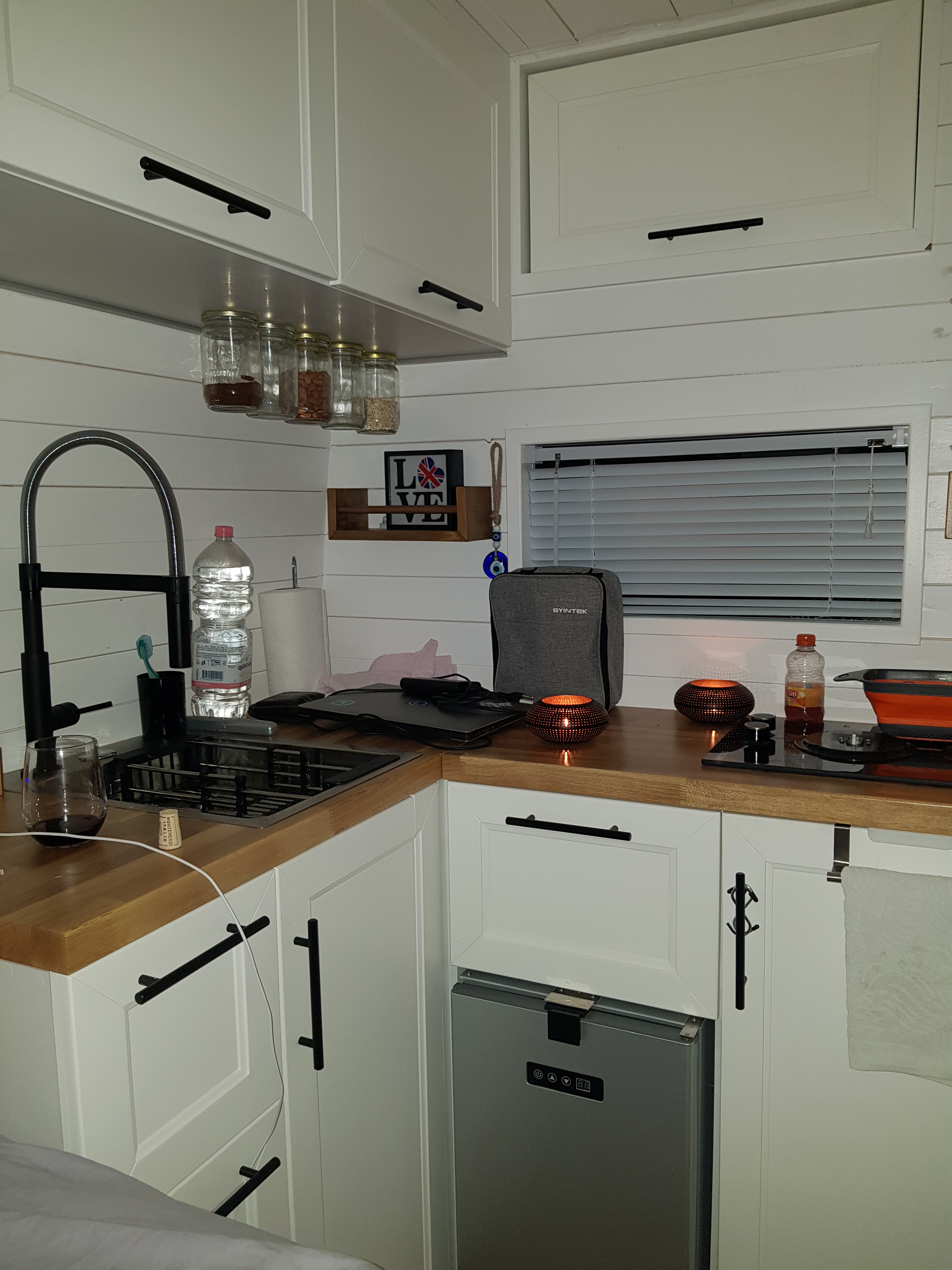 Cozy kitchen area of the DIY Mercedes Sprinter camper van, featuring modern amenities and a warm atmosphere.