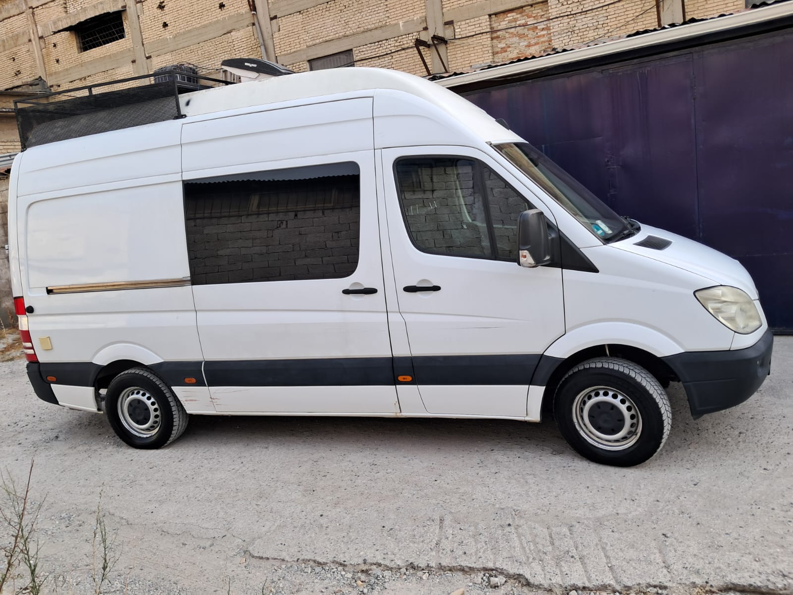 Side view of the DIY Mercedes Sprinter camper van available for rent in Albania, showcasing its sleek design and spacious layout.
