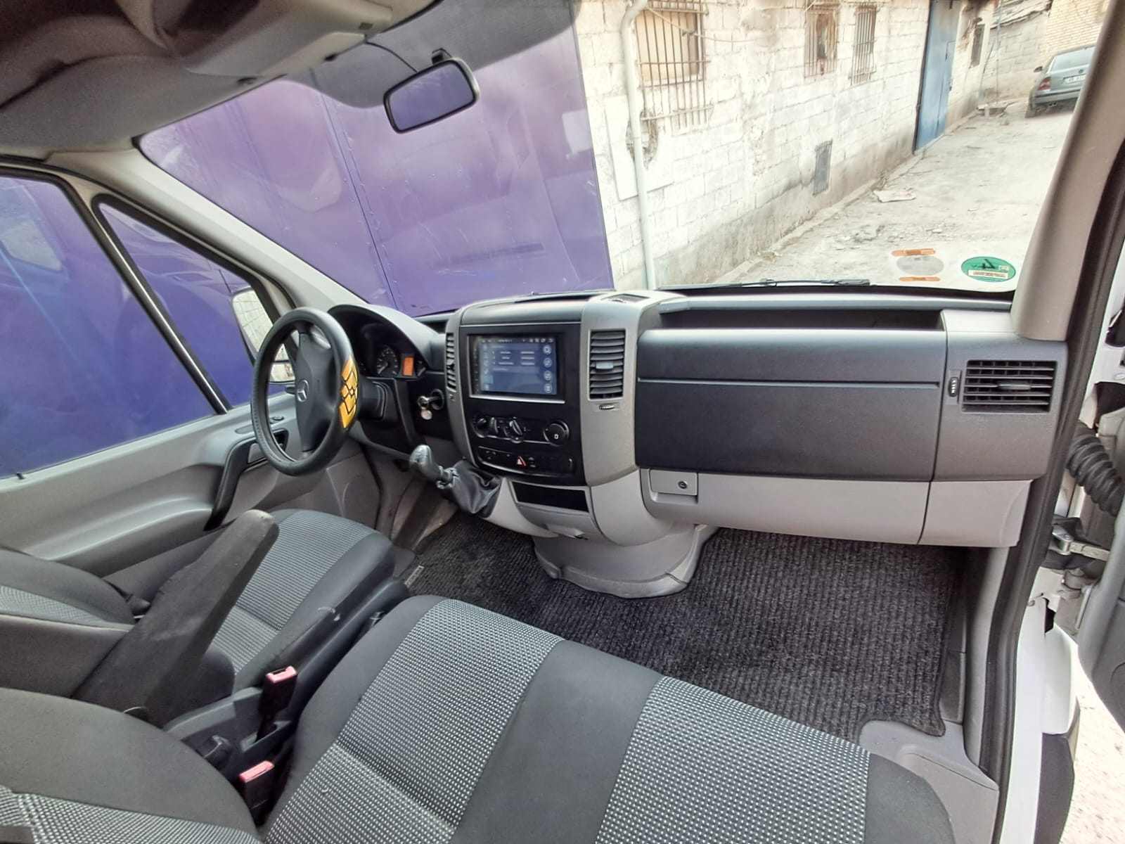 Interior view of the Mercedes Sprinter camper van, featuring comfortable seating and modern dashboard controls.